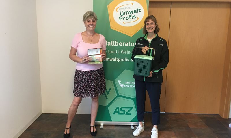 Gewinnfoto WL Gewinnerin Petra Kaiblinger steht mit Gutschein in der Hand neben Abfallberaterin Stephanie Wagner.