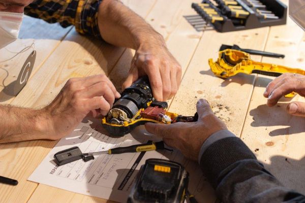 © Repair Café Ried Hände die ein Elektrogerät repaieren
